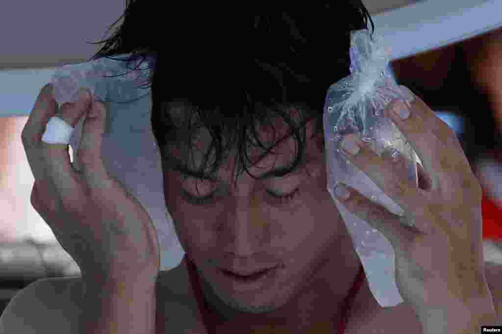 Kei Nishikori of Japan holds an ice pack to his face during a men&#39;s singles match against Dusan Lajovic of Serbia at the Australian Open 2014 tennis tournament in Melbourne. Organizers have been slammed for forcing players to play in searing temperatures.