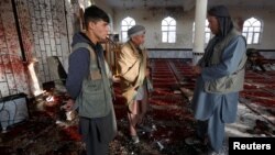 Afghan men inspect inside a Shi'ite Muslim mosque after a suicide attack in Kabul, Afghanistan October 21, 2017.