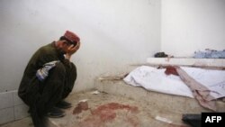 Một người đàn ông Pakistan ngồi khóc bên cạnh xác người thân thiệt mạng trong vụ nổ bom ở Quetta, ngày 7/9/2011