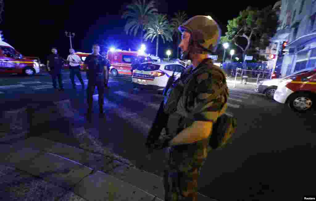 Tentara Perancis mengelilingi lokasi tempat sebuah truk menabrak kerumunan massa di Nice, Perancis, dalam perayaan hari libur nasional Hari Bastille, menewaskan sedikitnya 80 orang (15/7). (Reuters/Eric Gaillard)