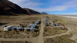 Residents walk along a dirt road in the Urus del Lago Poopo indigenous community, which sits along the salt-crusted former shoreline of Lake Poopo, in Punaca, Bolivia, Monday, May 24, 2021.