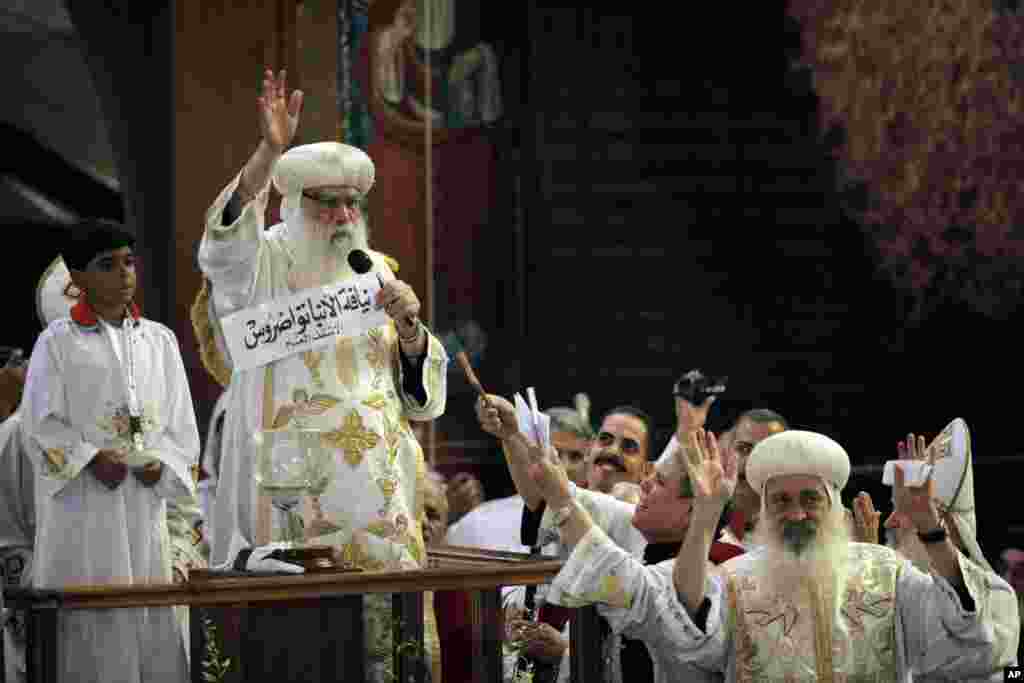 Acting Coptic Pope Bakhomious, center, displays the name of 60-year-old Bishop Tawadros, soon to be Pope Tawadros II, during the papal election ceremony at the Coptic Cathedral in Cairo, Egypt, November 4, 2012. 