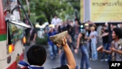 Para demonstran menyerang bis yang mengangkut pendukung pemerintahan yang sedang menuju rally di Bangkok, 30 Nov., 2013