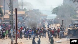 Des manifestants et la police anti-émeute s'affrontent dans une rue de Conakry, le 13 mars 2018