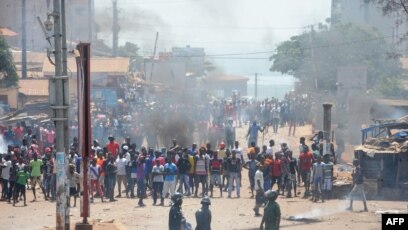 Des manifestants et la police anti-émeute s'affrontent dans une rue de Conakry, le 13 mars 2018