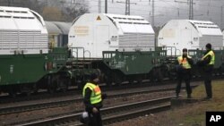 German police guard the train transporting Castor containers, which carry radioactive nuclear waste, during a stop in Neunkirchen near Saarbruecken November 25, 2011.