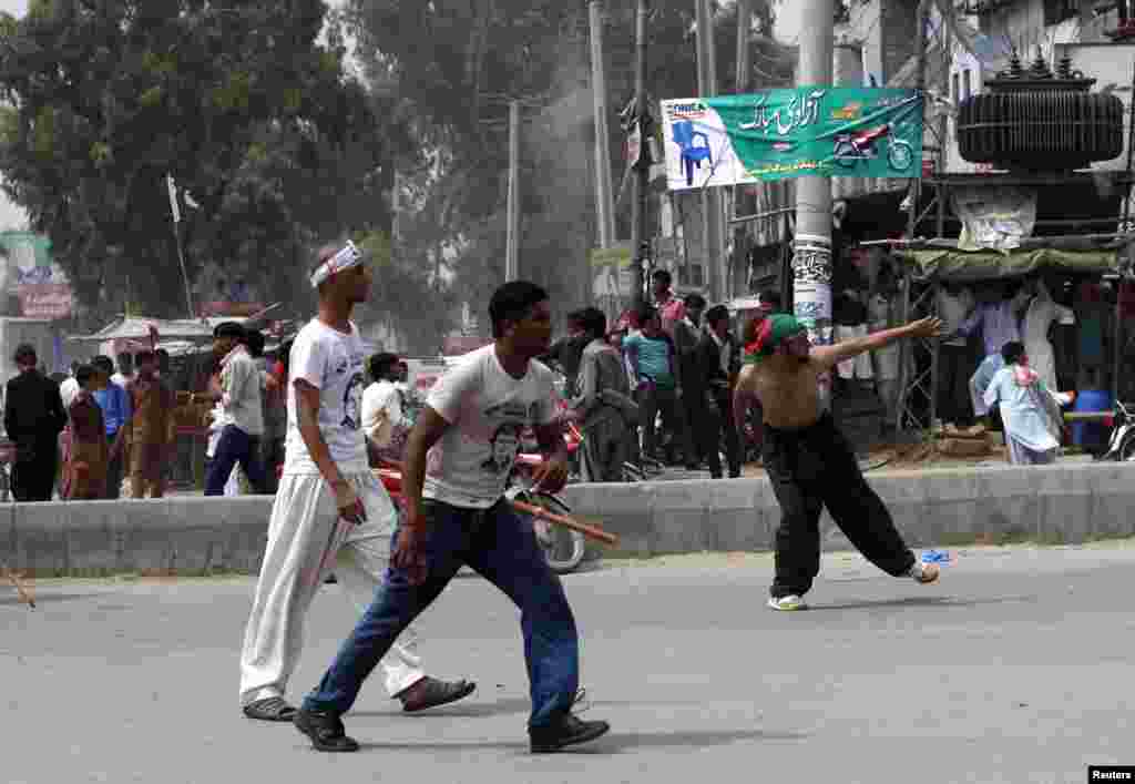 Clashes broke out between supporters and non-supporters of politician Imran Khan, with both parties throwing rocks at each other, at the Freedom March, in Gujranwala, Aug. 15, 2014.