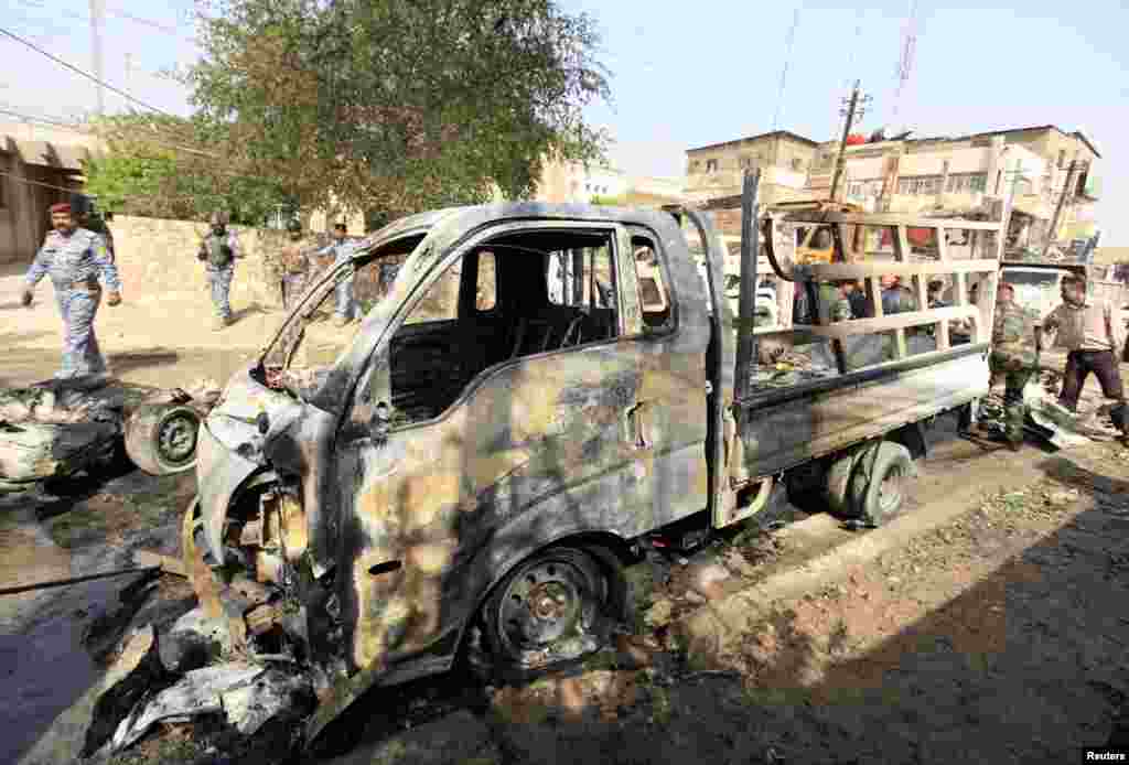 Security forces inspect the site of car bomb attack in Baghdad, March 5, 2014. 