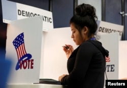 First-time voter Kimberly Medina, 19, votes during the U.S. presidential primary election at Gates Street Elementary School in Los Angeles, California, June 7, 2016.