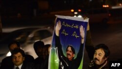 Pakistani lawyers hold up a poster of Supreme Court Chief Justice Iftikhar Muhammad Chaudhry as they mark his retirement outside the Supreme Court building in Islamabad, Dec. 11, 2013. 