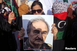 FILE - A woman holds a portrait of Khalifa Haftar in Benghazi, Libya, Aug. 1, 2014.
