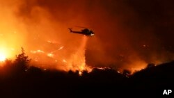 Un helicóptero lanza agua sobre un incendio en Bonsall, California, el 7 de diciembre.