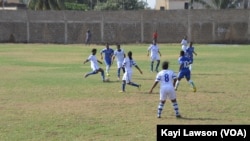 Les équipes d'Athleta FC (blanc) et le club "les amis du monde" (bleu) se rencontrent à Lomé, au Togo, le 18 mars 2017. (VOA/Kayi Lawson)