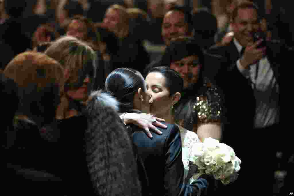 Beberapa pasangan yang berpartisipasi dalam pernikahan sesama jenis yang berlangsung saat pertunjukan lagu &quot;Same Love&quot; dari Macklemore and Ryan Lewis pada Grammy Awards ke-56. (AP/Matt Sayles)