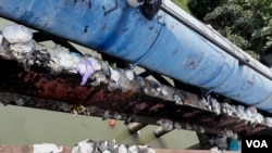 Tumpukan sampah popok di pinggir jembatan Surabaya, yang dibuang sembarangan oleh warga yang tidak bertanggung jawab. (Foto: VOA/Petrus Riski)