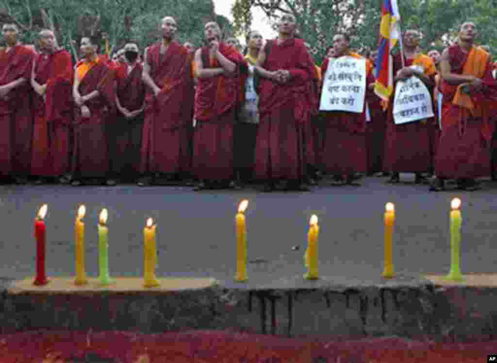 Tibetan exile monks stand during a candlelit vigil in New Delhi, India, to express solidarity with the plight of the Tibetan people in Tibet, Tuesday, Oct. 18, 2011