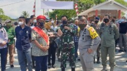 Gubernur Sulawesi Tengah, Rusdy Mastura (selempang merah) saat mengunjungi Pos Komando Taktis Operasi Madago Raya di Tokorondo, Poso Pesisir, Kabupaten Poso. Sabtu (31/7/2021). (Foto: VOA/Yoanes Litha)