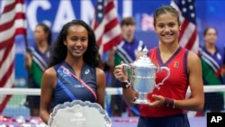 Leylah Fernandez and Emma Raducanu pose with their trophies after the U.S. Open final on Saturday.