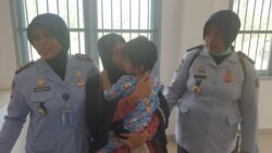 Sambil memeluk anak perempuannya yang berusia satu setengah tahun Asmawati menyerahkan diri ke Lapas Perempuan Kelas III Palu, 30 September 2019. (Foto: VOA/Yoanes Litha)