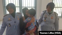 Sambil memeluk anak perempuannya yang berusia satu setengah tahun Asmawati menyerahkan diri ke Lapas Perempuan Kelas III Palu, 30 September 2019. (Foto: VOA/Yoanes Litha)