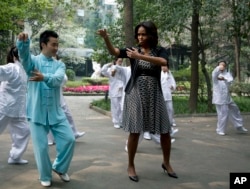 U.S. first lady Michelle Obama practices tai chi with students at Chengdu No.7 High School in Chengdu in southwest China's Sichuan province, March 25, 2014.