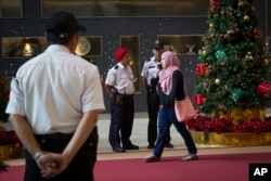 Security personnel stand guard at the entrance of a shopping mall ahead of the Christmas celebrations in Kuala Lumpur, Malaysia, Thursday, Dec. 22, 2016.