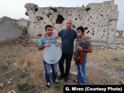 Kurdish musician Gani Mirzo pictured with two blind students in Kobani, Syria, July 2018. (courtesy: Gani Mirzo)