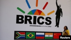 A delegate walks past a BRICS logo ahead of the 10th BRICS Summit, in Sandton, South Africa, July 24, 2018. 
