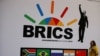 FILE - A delegate walks past a BRICS logo ahead of the 10th BRICS Summit, in Sandton, South Africa, July 24, 2018. 