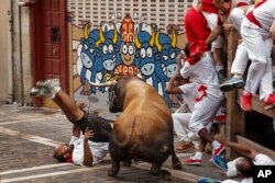 A reveler is gored by a Cebada Gago's ranch fighting bull during the running of the bulls in Pamplona, Spain, July 8, 2016.