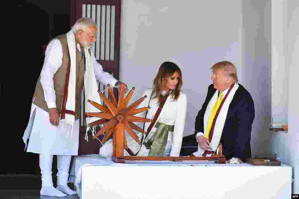 U.S. President Donald Trump and First Lady Melania Trump listen to India&#39;s Prime Minister Narendra Modi (L) as they sit next to a charkha, or spinning wheel, during their visit at Gandhi Ashram in Ahmedabad.