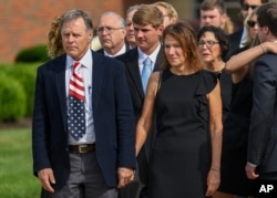 FILE - Fred and Cindy Warmbier watch as their son Otto's casket is placed in a hearse after funeral services, in Wyoming, Ohio, June 22, 2017.
