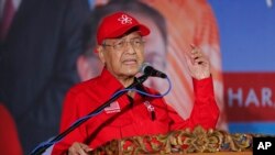 FILE - Malaysian Prime Minister Mahathir Mohamad delivers his speech during a rally for Anwar Ibrahim in Port Dickson, Malaysia, Oct. 8, 2018. 