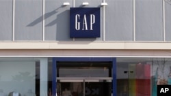 People walk past a Gap store at the Derby Street Shoppes complex in Hingham, Massachusetts, February 21, 2012