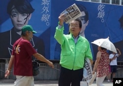 A staff of a Japanese newspaper hands out passer-by an extra edition reporting North Korea's rocket launch at a street corner in Tokyo, Aug. 29, 2017.