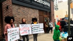 Protesters gather outside a Starbucks in Philadelphia, April 15, 2018, where two black men were arrested Thursday after Starbucks employees called police to say the men were trespassing.