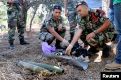 Lebanese army personnel inspect the remains of a shell suspected of having been launched from Lebanon to Israel, near the village of El Mari in southern Lebanon July 11, 2014.