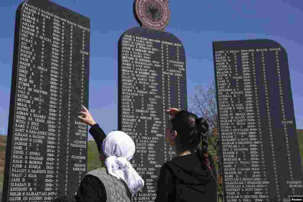 Kosovo Albanians read the names of the victims killed during the 1998-1999 Kosovo war, as part of a ceremony marking the 18th anniversary of the massacre in the village of Izbica.