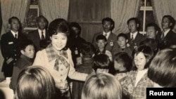FILE - Park Geun-hye greets children when she served as her father and then-President Park Chung-hee's first lady in the 1970s, after her mother Yuk Young-soo was assassinated by a North Korean-backed gunman.