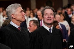 FILE - Supreme Court Associate Justices Neil Gorsuch, left, and Brett Kavanaugh watch as President Donald Trump arrives to give his State of the Union address to a joint session on Congress at the Capitol in Washington, Feb. 5, 2019.