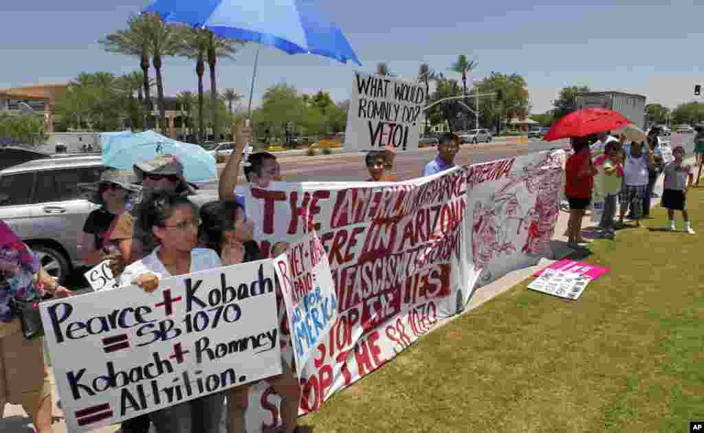 Demonstrators gather in Scottsdale, Arizona to protest against Mitt Romney (speaking inside a nearby resort) as well as the immigration law SB1070.