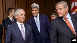El secretario de Estado, John Kerry, acompañado a la izquierda, por el presidente entrante de la Comisión de Relaciones Exteriores, Bob Corker, y por el saliente, Bob Menéndez.