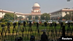 A television journalist sets his camera inside the premises of the Supreme Court in New Delhi, Feb. 18, 2014.