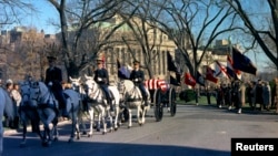The funeral caisson carrying the casket of former U.S. President John F. Kennedy enters the White House driveway in Washington, in this handout image taken on Nov. 25, 1963.