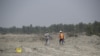 FILE - Construction workers walk along the island of Bhasan Char in the Bay of Bengal, Bangladesh, Feb. 14, 2018.