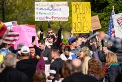 Para pengunjuk rasa memprotes penerapan aturan tinggal di rumah yang diterapkan Kentucky, 15 April 2020.