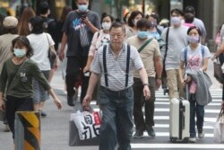 Para pejalan kaki menyeberang jalan di distrik perbelanjaan di Taipei, Taiwan, di tengah pandemi Covid-19, Kamis, 29 Oktober 2020.