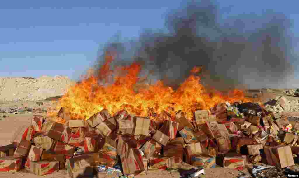 Boxes of goods burn in central Ragga, Syria. Men who said they were hired by the Islamic State took the goods, as part of monitoring the quality of goods in markets. 