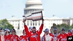Washington Capitals' Alex Ovechkin, of Russia, holds up the Stanley Cup trophy during the NHL hockey team's Stanley Cup victory celebration, June 12, 2018, at the National Mall in Washington. 