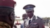FILE - Burkina Faso coup leader Gen. Gilbert Diendere, center, greets people at the airport during the arrival of Niger's President Mahamadou Issoufou for talks in Ouagadougou, Burkina Faso, Sept. 23, 2015. The trial for 84 people accused of masterminding